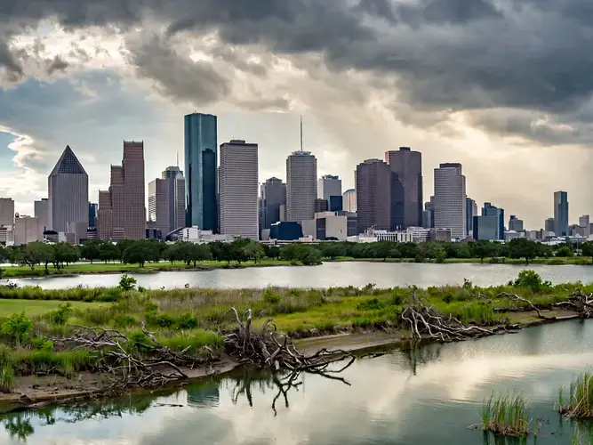A city skyline with tall buildings and a body of water in front of it.